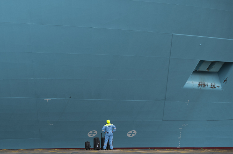 Homem ao lado de casco de navio