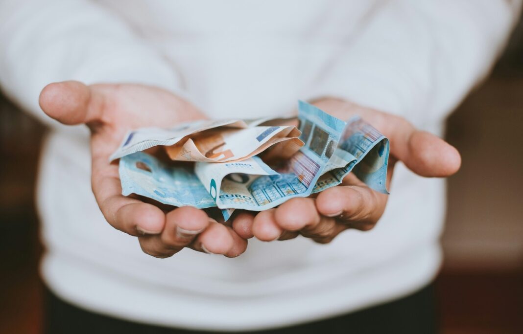 hOMEM COM CÉDULAS DE EURO NAS MÃOS