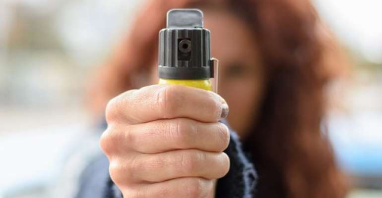 Mulher portando spray de pimenta