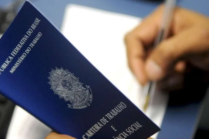 Homem assinando carteira de trabalho