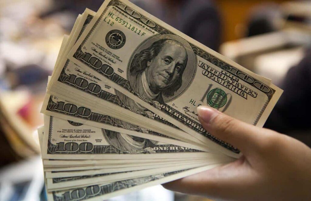 Mulher segurando cédulas de dolar