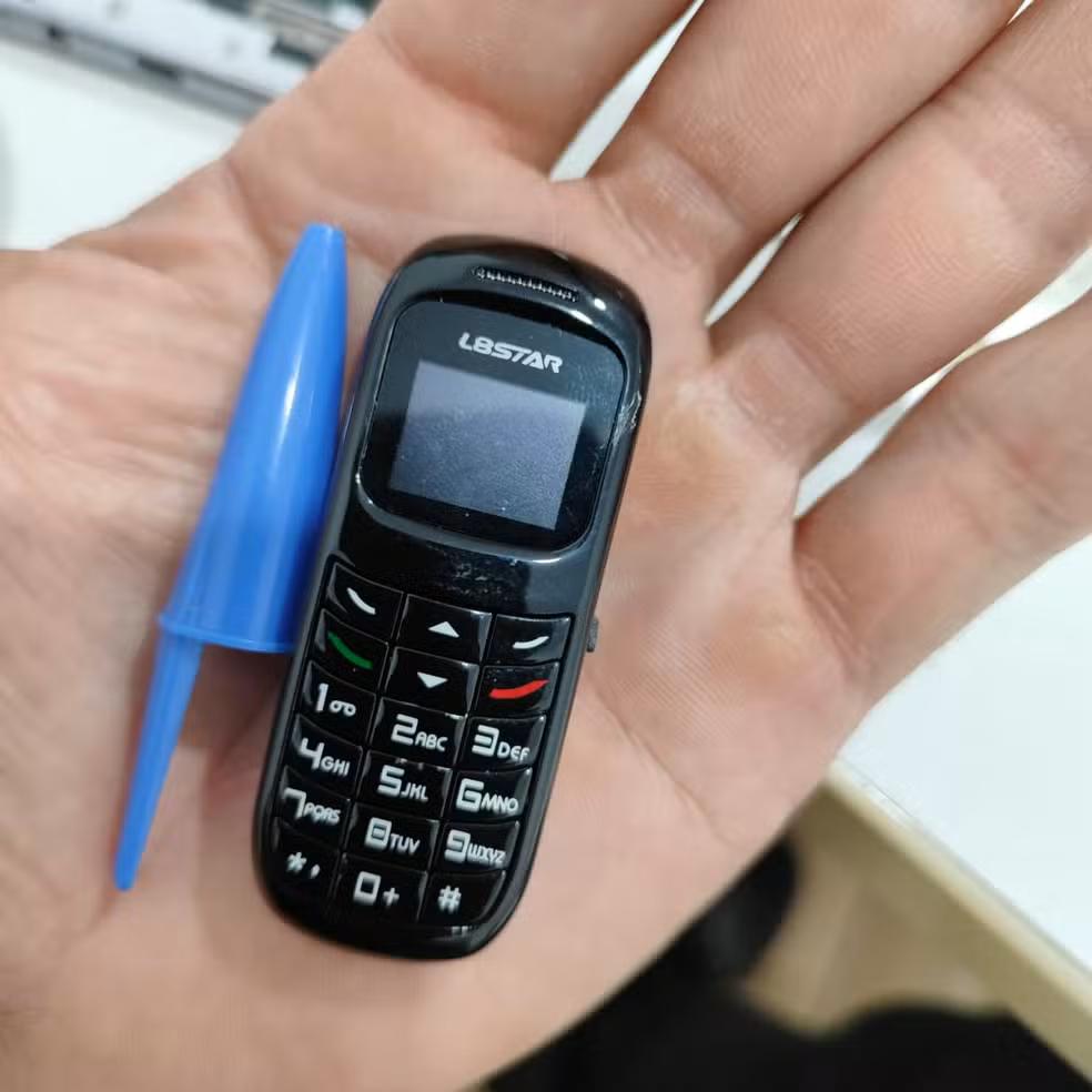Celular e bocal de caneta na palma da mão